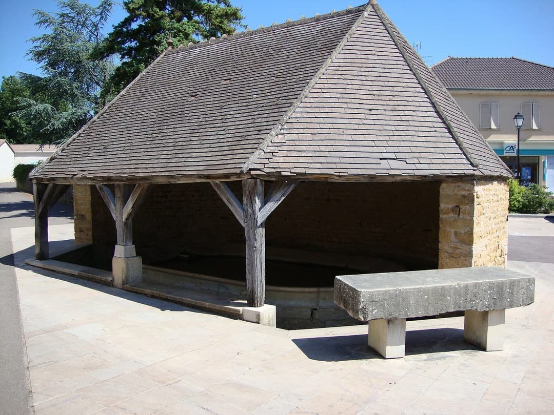Un lavoir couvert en pierre au bord de l'eau