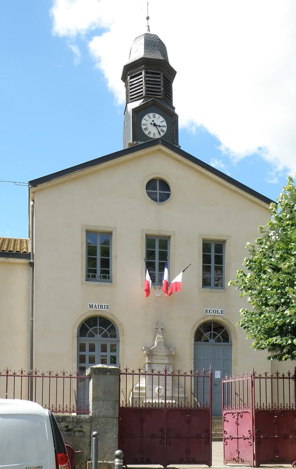 La façade d'une mairie de village, drapeau tricolore au balcon